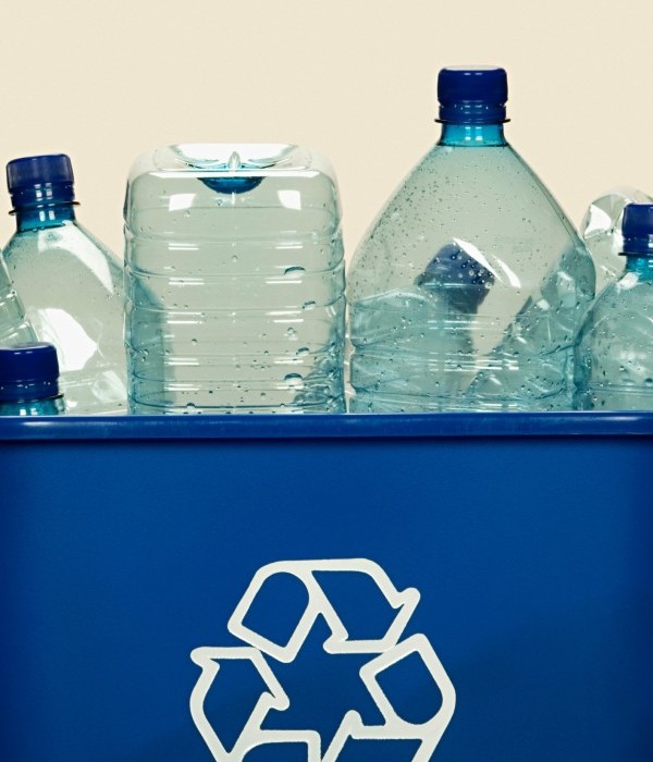 Recycling bin full of empty clear bottles.