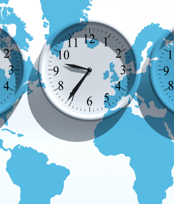 Blue and white graphic of the world map with different timed clocks in the forefront.