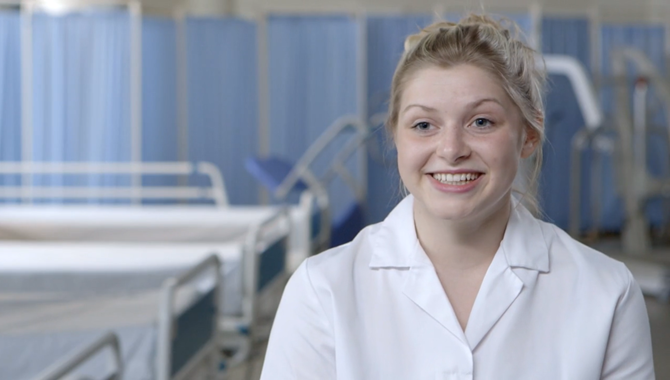 Student of Health Sciences department in a hospital smiling at the camera