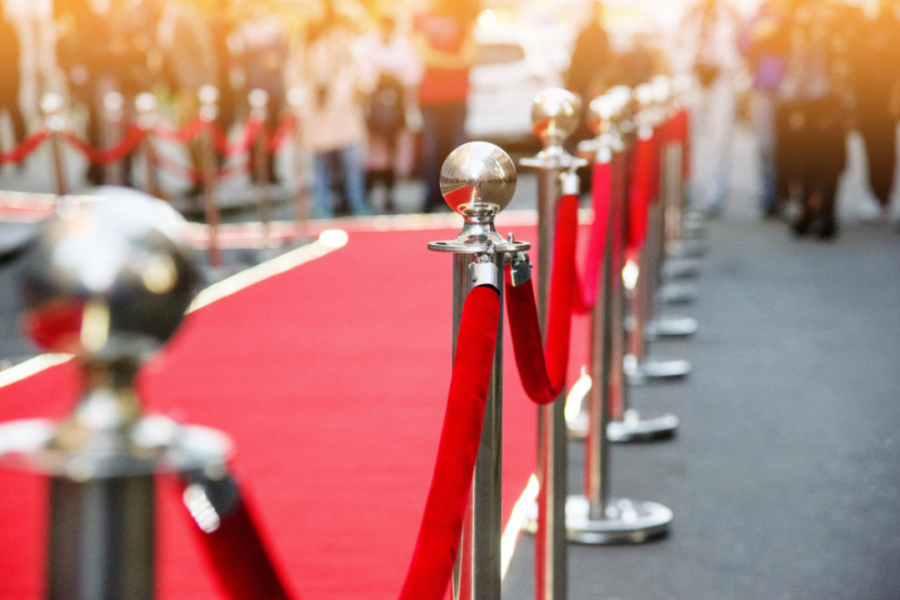 An image of a red carpet with red rope and golden stands