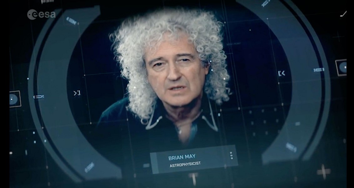 Brian May talking in front of a camera.