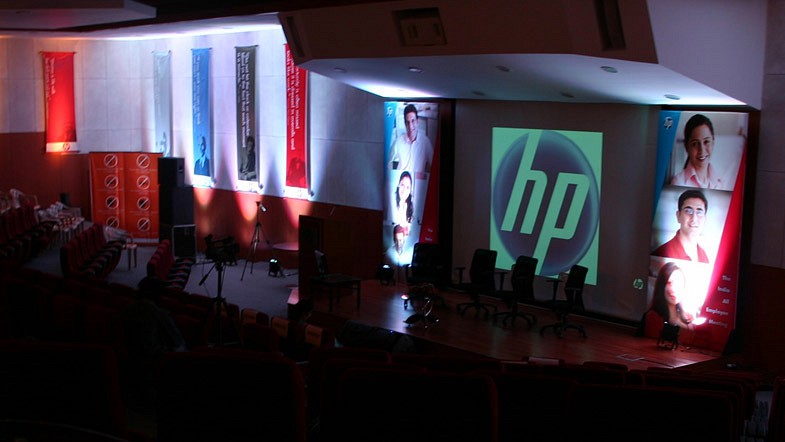 A stage and screen with HP branding and a live audience.